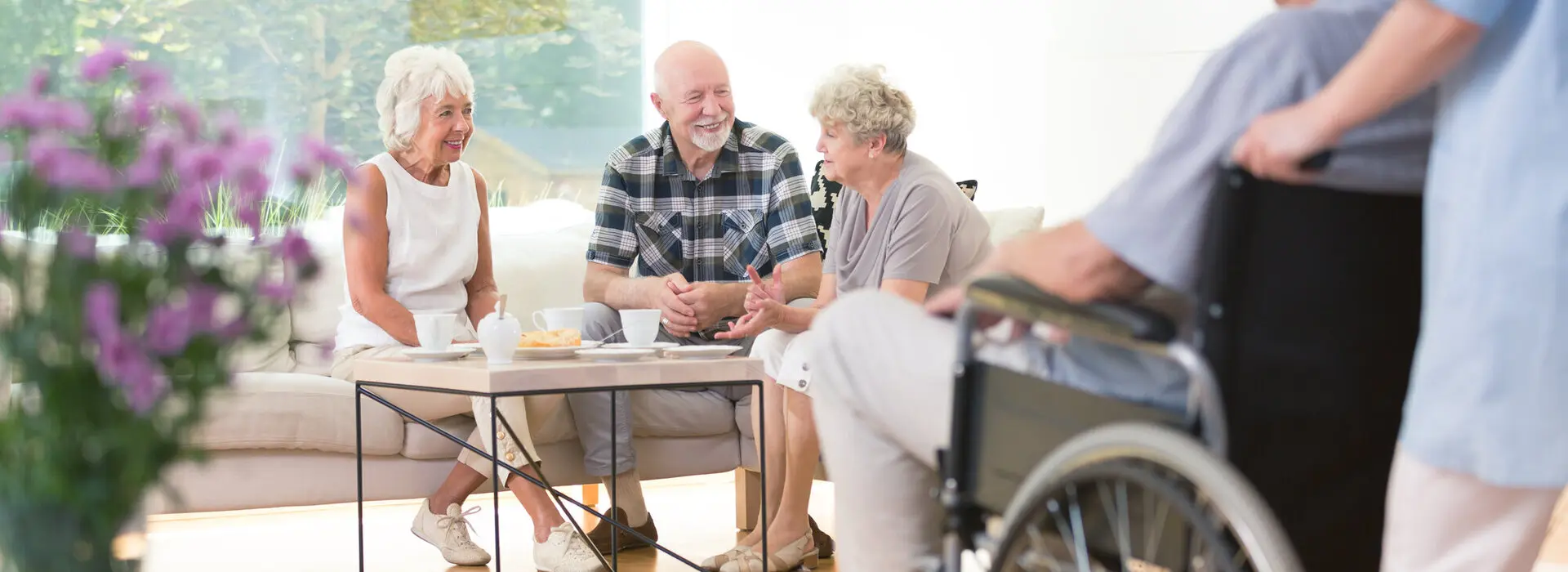 Gruppe von älteren Personen sitzt gemeinsam in einem Raum und unterhalten sich.