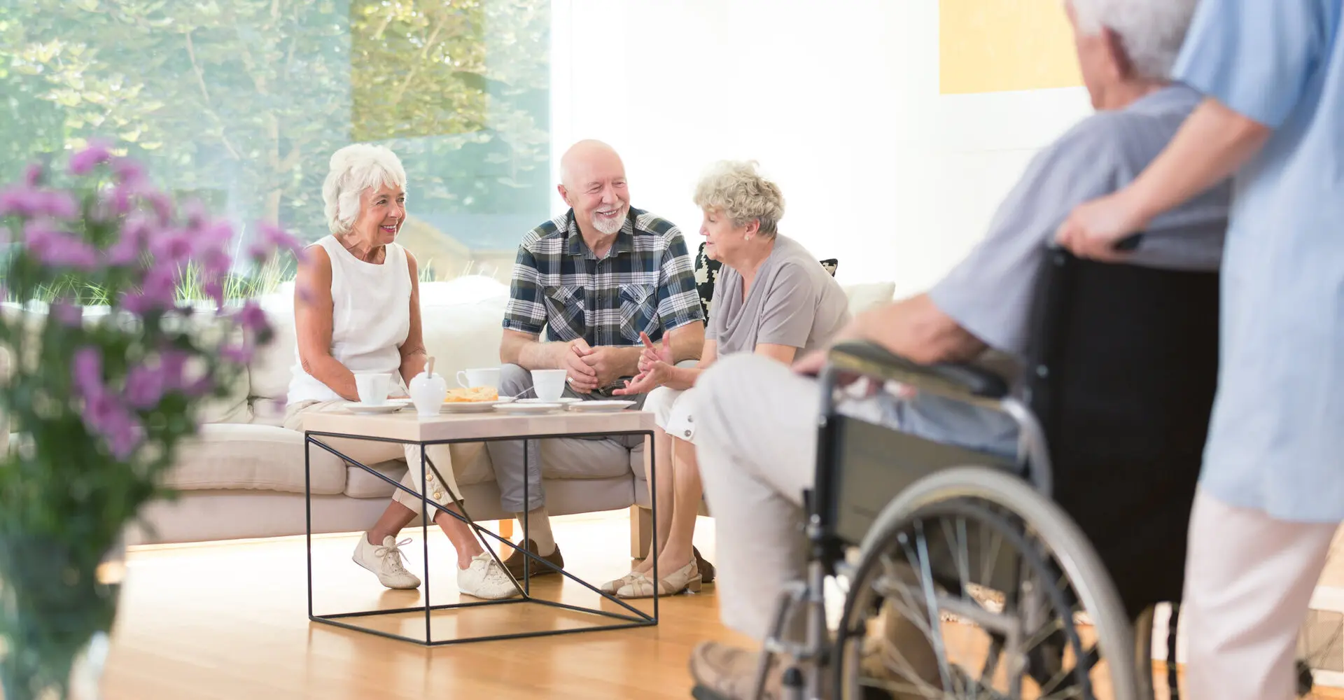 Gruppe von älteren Personen sitzt gemeinsam in einem Raum und unterhalten sich.